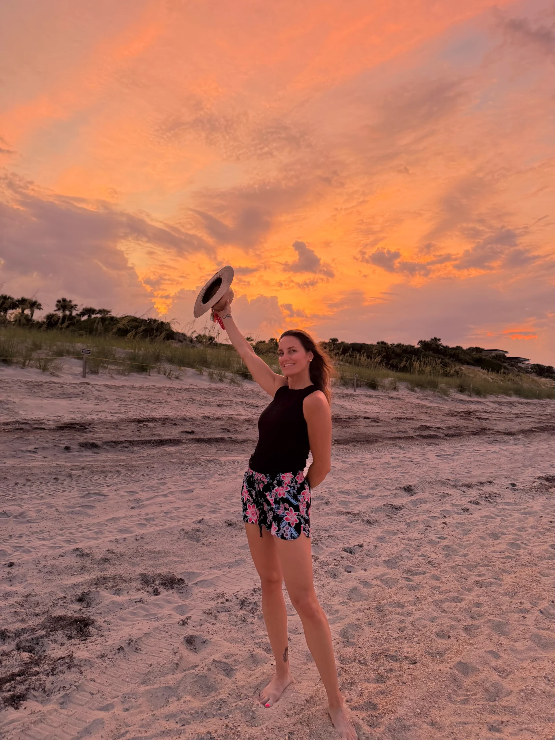 April Liles standing on the beach at sunset