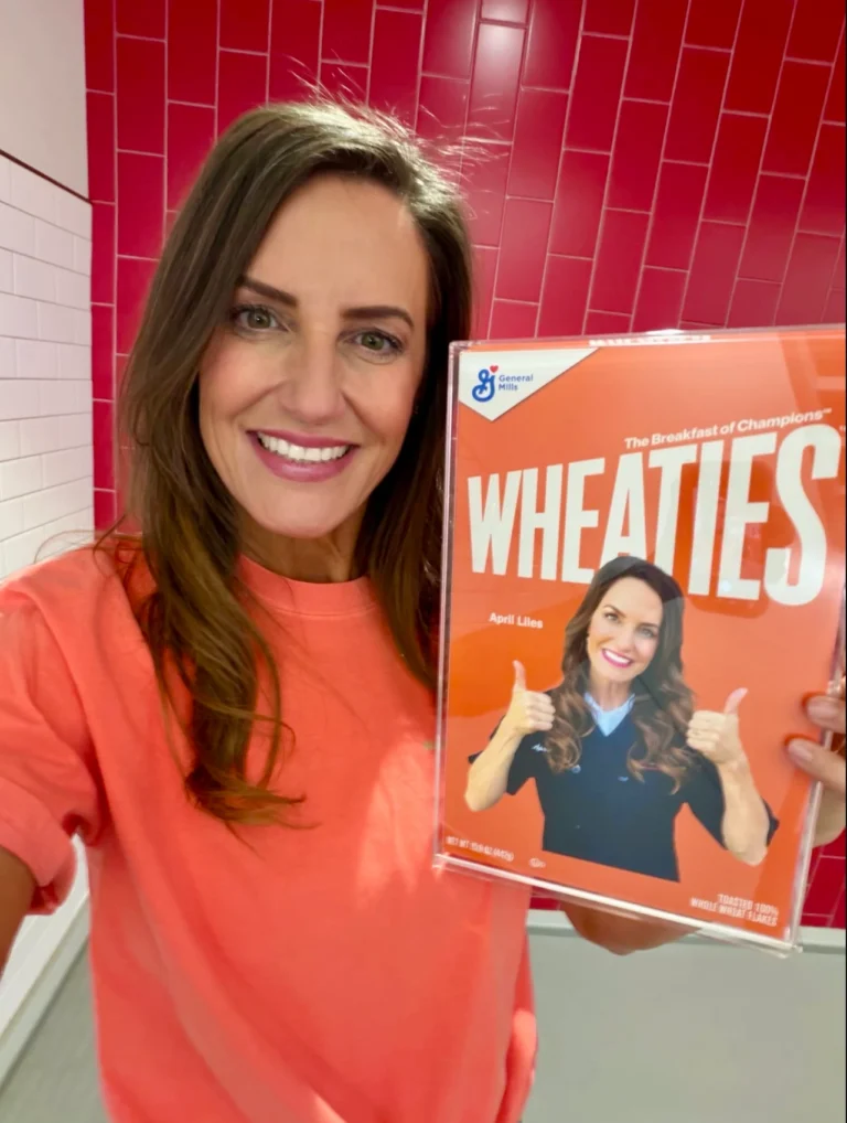 April Liles holding a personalized Wheaties box featuring her photo