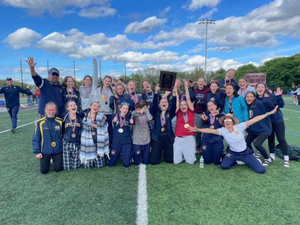 April Liles celebrating with her track and field team after a competition