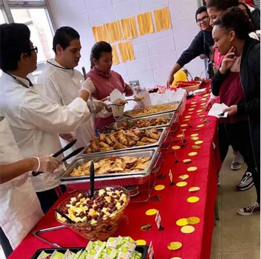Students serving freshly prepared food during a K-12 school nutrition culinary program